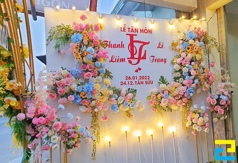 Mẫu 1: Background sự kiện đám cưới được thiết kế với tông màu trắng chủ đạo, tên của cô dâu & chú rể được thiết kế với kiểu chữ nghệ thuật