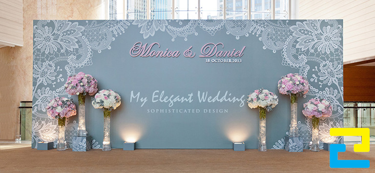 Mẫu 3: Background cho sự kiện đám cưới khổ lớn được thiết kế với họa tiết đẹp mắt, có kiểu chữ nghệ thuật - đơn giản, được trang trí thêm những chậu hoa