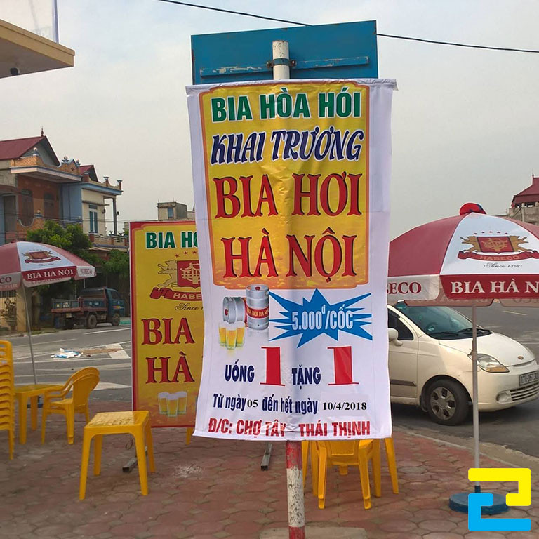 Mẫu 3: Băng rôn khổ dọc được thiết kế với tông màu trắng - vàng, thông điệp quảng cáo được thiết kế nổi bật, có hình ảnh minh họa