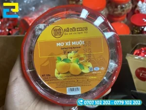 In tem nhãn ô mai bế tròn dán trên nắp hộp ô mai