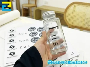 Sticker decal trong suốt in mực UV hiển thị rõ nét logo khi dán lên bề mặt bình, chai lọ thủy tinh và cửa kính