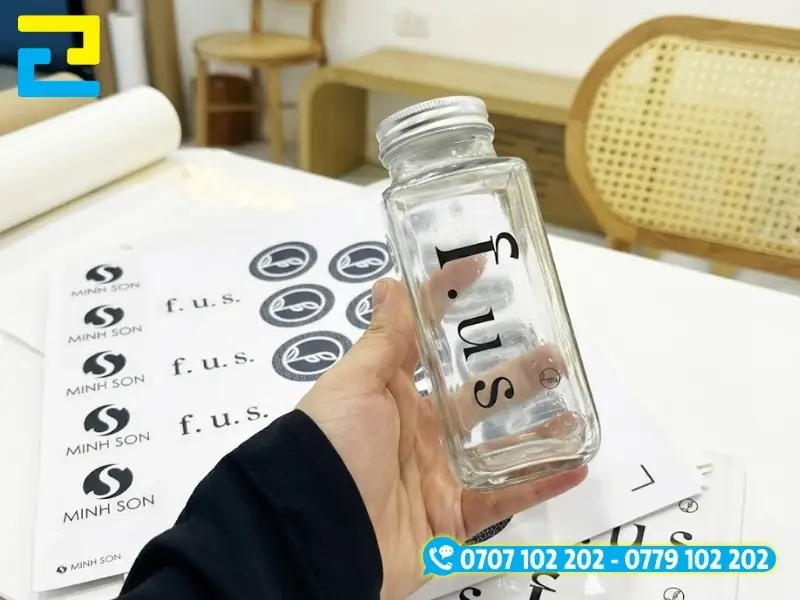 Sticker decal trong suốt in mực UV hiển thị rõ nét logo khi dán lên bề mặt bình, chai lọ thủy tinh và cửa kính