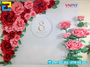 Mẫu 14: Backdrop 8/3 đẹp mang phong cách đơn giản, được thiết kế với hình ảnh viền hoa hồng đẹp mắt, có tông màu trắng chủ đạo