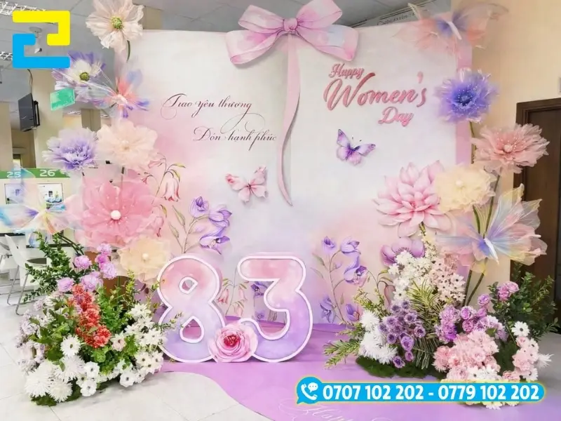 Mẫu 17: Mẫu backdrop 8/3 được thiết kế đơn giản với tông màu trắng tím chủ đạo, có kiểu chữ đơn giản - nghệ thuật đẹp mắt, được trang trí hoa xung quanh