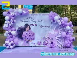 Mẫu 18: Phông nền 8-3 được trang trí bóng bay và hoa, có tông màu trắng - tím, kết hợp với kiểu chữ nghệ thuật - đơn giản